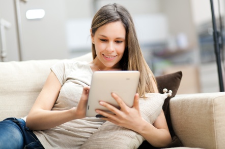 Young woman using a tablet on the sofa
